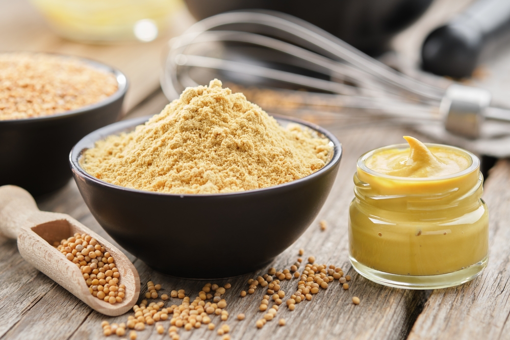 Mustard sauce jar and bowl of powdered mustard seeds